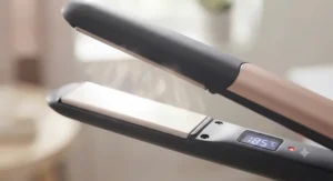 Close-up of ceramic-coated hair straightener plates heating up for smooth styling.
