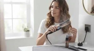 User holding fast-heating hair straighteners under £50 in a bathroom setting.